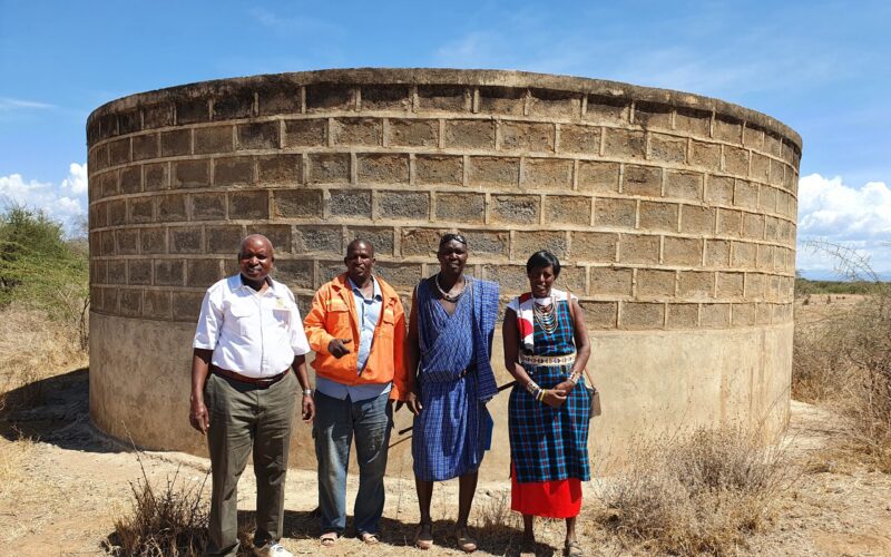 20201126_134946 Members of the community standing in front of water storage tank